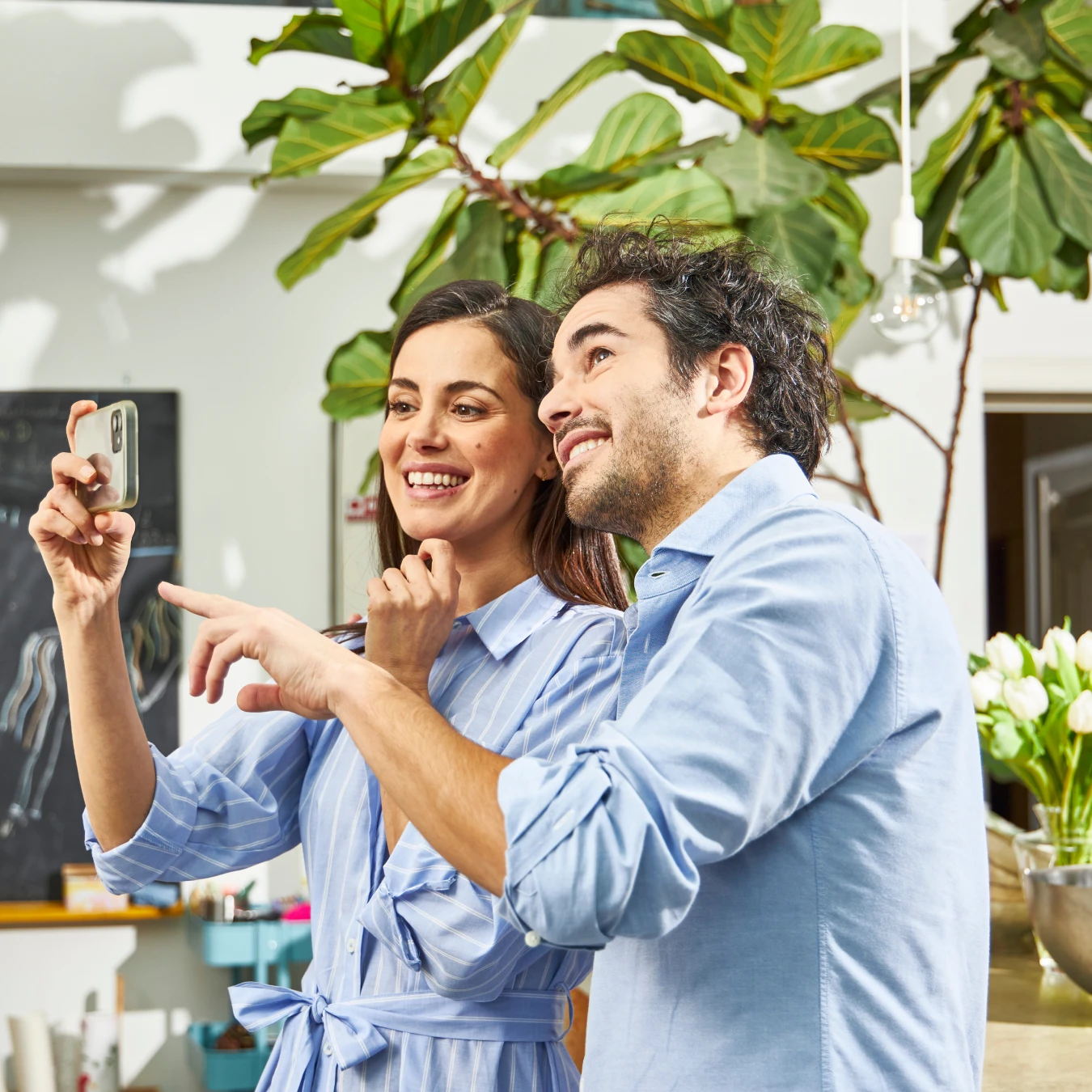 Couple taking selfie in modern living space with plants